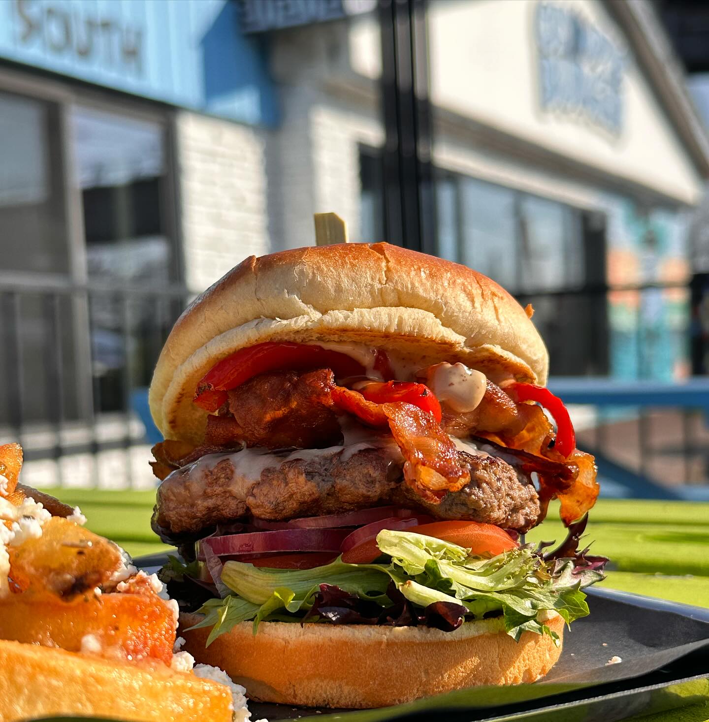 image of burger with restaurant in background